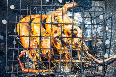 Büyük nehir karidesi ateşte kızartılmış deniz mahsulü yemeğiyle.