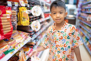 Öğrenci çocuk marketteki mini süpermarketten yiyecek ve içecek almayı sever.