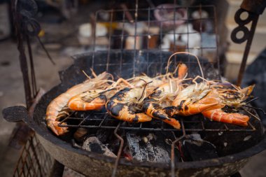Nehir karidesi dev karidesler ateşte kızartılıyor. Meşhur Asya yemekleri sıcak ve baharatlı.