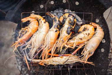 Nehir karidesi dev karidesler ateşte kızartılıyor. Meşhur Asya yemekleri sıcak ve baharatlı.