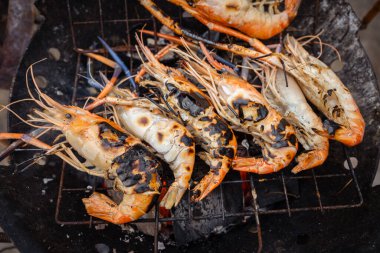 Nehir karidesi dev karidesler ateşte kızartılıyor. Meşhur Asya yemekleri sıcak ve baharatlı.