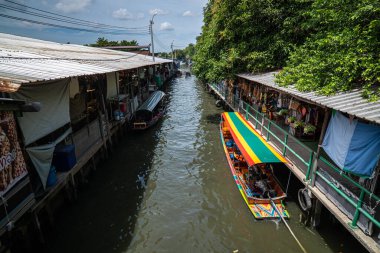 Yerli ahşap tekne yüzen pazarda Klong delikanlı mayom Bangkok Tayland 'da geleneksel yiyecek ve içecek pazarını geziyor.