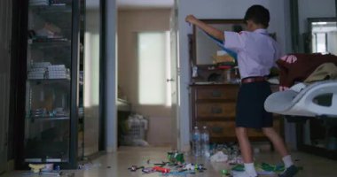 Küçük okul çocuğu rahat bir evde tek başına üniforma giyer, okula geri döner. 