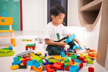 Küçük anaokulu çocuğu okul eğitiminde renkli oyuncaklar inşa etmekten zevk alıyor.