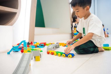 Küçük anaokulu çocuğu okul eğitiminde renkli oyuncaklar inşa etmekten zevk alıyor.