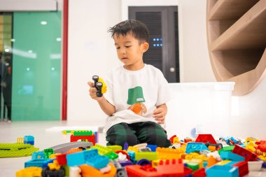 Anaokulu Asyalı çocuk okul eğitiminde renkli oyuncaklar inşa etmekten zevk alıyor.