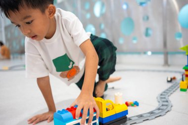 Anaokulu Asyalı çocuk okul eğitiminde renkli oyuncaklar inşa etmekten zevk alıyor.