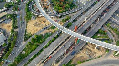 Vinç taşımacılığı endüstrisi ile kavşak nakliye yolunun inşa edildiği hava manzaralı inşaat alanı