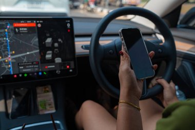 İş kadını, arabayı güvenli bir şekilde sürerken akıllı telefon kullanır.