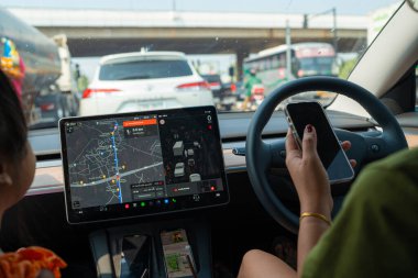 İş kadını, arabayı güvenli bir şekilde sürerken akıllı telefon kullanır.