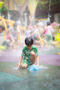 Mutlu Asyalı anaokulu çocuğu Aqua Park 'ta yaz tatili aktivitelerinin tadını çıkarıyor.