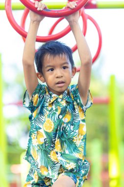 Okul çocuğu dışarıda oyun parkına tırmanmayı seviyor.