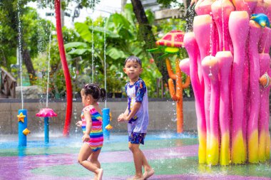 Küçük mutlu anaokulu çocuğu ve kızı suyun tadını çıkarıyorlar. Su parkı yaz tatili aktivitesi.