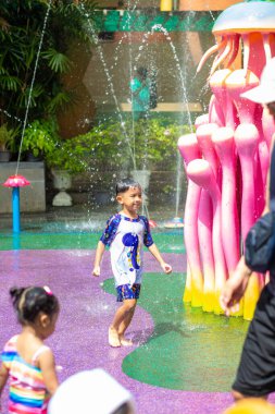 Küçük mutlu anaokulu çocuğu ve kızı suyun tadını çıkarıyorlar. Su parkı yaz tatili aktivitesi.