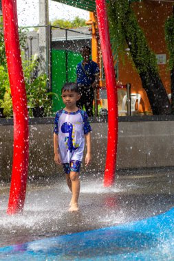 Küçük mutlu anaokulu çocuğu ve kızı suyun tadını çıkarıyorlar. Su parkı yaz tatili aktivitesi.