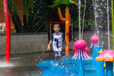 Küçük mutlu anaokulu çocuğu ve kızı suyun tadını çıkarıyorlar. Su parkı yaz tatili aktivitesi.