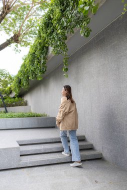 Asyalı iş kadını şehirde rahatlayıp modern yaşam tarzı mutlu bir kadın yaratıyor.