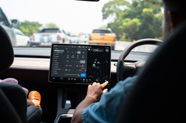 Kadın EV kullanıyor. Yol taşıma teknolojisinde GPS kullanılıyor.