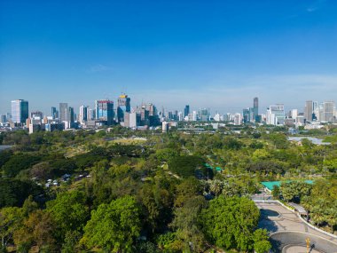 Bangkok Tayland şehir merkezindeki Benchakitti halk parkında tropik yeşil ağaç parkı olan modern ofis binası.
