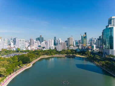 Bangkok Tayland şehir merkezindeki Benchakitti halk parkında tropik yeşil ağaç parkı olan modern ofis binası.