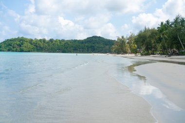Beyaz kumlu deniz plajı dalgaları mavi gökyüzü bulutlu yaz tatili arka planı