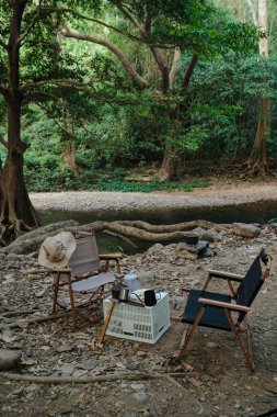 Nehir kenarındaki derin ormanlarda kamp sandalyesi doğa tatili.