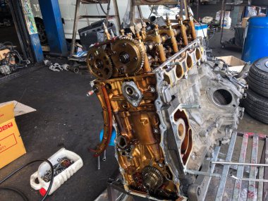 Tamirci, karşı arabanın motorunu garajda tamir için söker. Araç motoru içeriden görünümü kapat