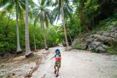Mutlu küçük oğlan ve kız, tropikal ormanda kamp yolculuğunun keyfini çıkarın.