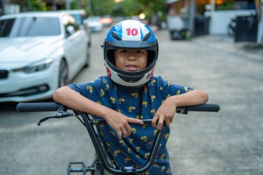 Küçük okul çocuğu şehir merkezinde bisiklet sürerken dışarıda egzersiz yapıyor.