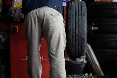 Araba lastiği değiştirme ve garajda yeni lastik denetimi.