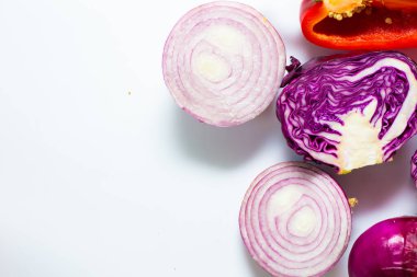 Beyaz arka plandaki vitamin yiyeceğinin üzerinde çeşitli sağlıklı sebzeler var.