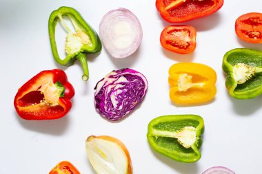 Beyaz arka plandaki vitamin yiyeceğinin üzerinde çeşitli sağlıklı sebzeler var.