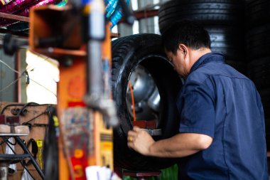 Teknik adam araba lastiği dükkanında çalışıyor.