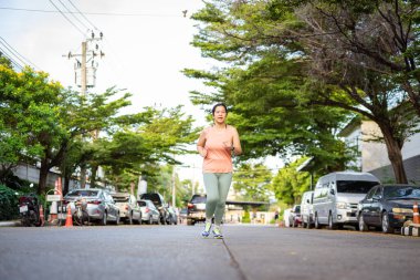 Spor atletik kadın şehri açık havada sabah güneşli ve sağlıklı bir yaşam tarzıyla koşuyor.