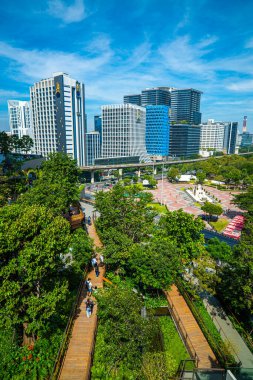 Lumpini yeşil tropikal orman parkı güneşli gün manzarası Dusit Central Park alışveriş merkezi Bangkok Tayland 'dan