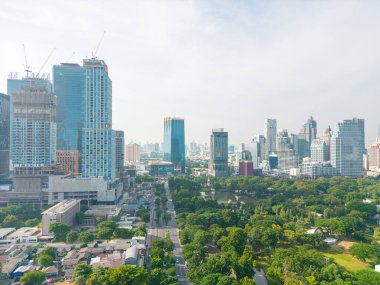 Gökyüzü manzaralı yeşil ağaç ormanı Lumpini halk parkı modern ofis binası devasa mavi bir gökyüzü bulutu Bangkok Tayland