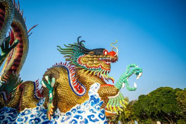 Mavi gökyüzüne karşı sabah vakti renkli ejderha heykeli Çin yeni yılı Nakornsawan Tayland