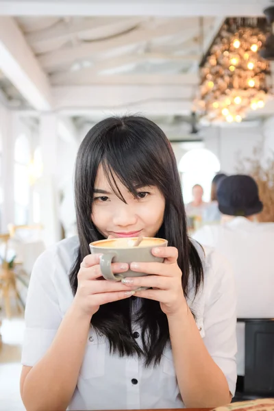 Азиатская девушка держит чашку кофе — стоковое фото