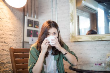 Asya gülümseyen kadın kahve içme 