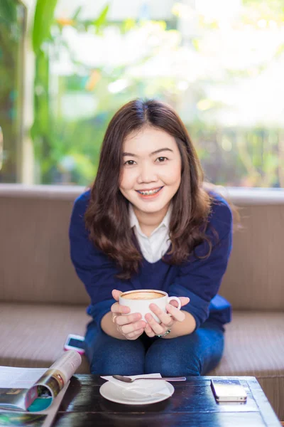 Attraente giovane donna seduta sul divano a bere caffè — Foto Stock