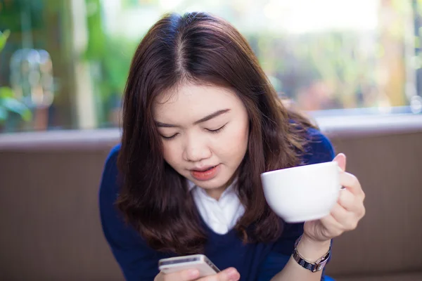 Young woman drinks coffee at cafe — Stock Photo, Image