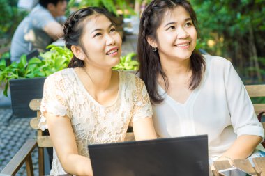 Asya businees kadın arkadaşı kahve dükkanında laptop ile zevk