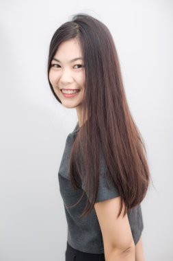 Bautiful Asyalı kız gri arka plan stüdyo üzerinde gülümseyen