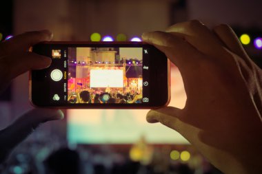 İnsanlar akıllı telefon resim çekmek bir konserde kullanın. 