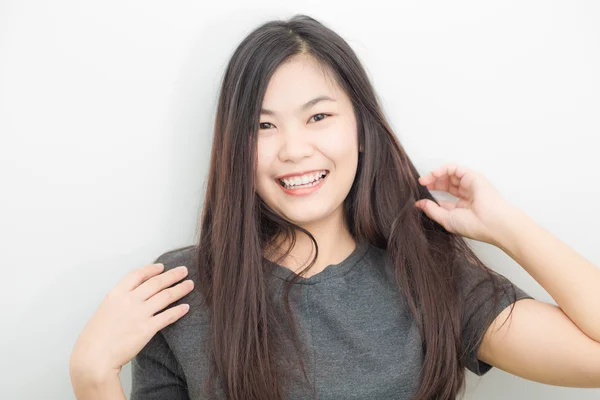 Bautiful asiatische Mädchen lächelnd auf grauem Hintergrund Studio — Stockfoto