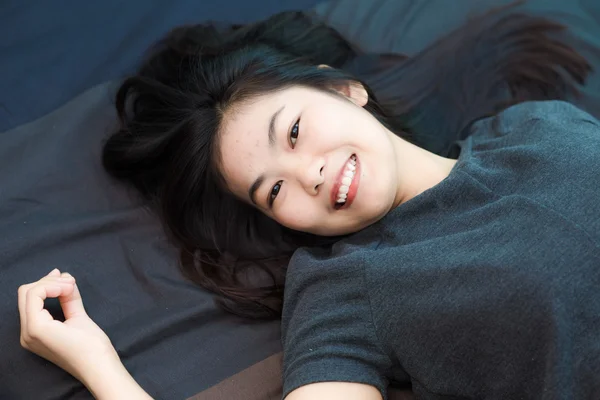 Modefoto der schönen jungen asiatischen Frau, die auf dem Bett liegt — Stockfoto