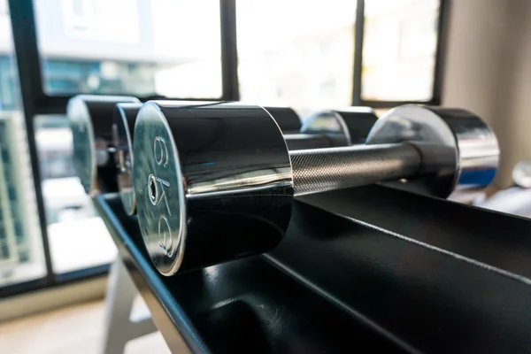 Dumb bells lined up in fitness room — Stock Photo, Image