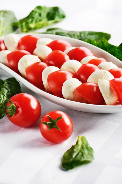 Dish with sliced mozzarella cheese balls and ripe cherry tomatoe — Stock Photo, Image