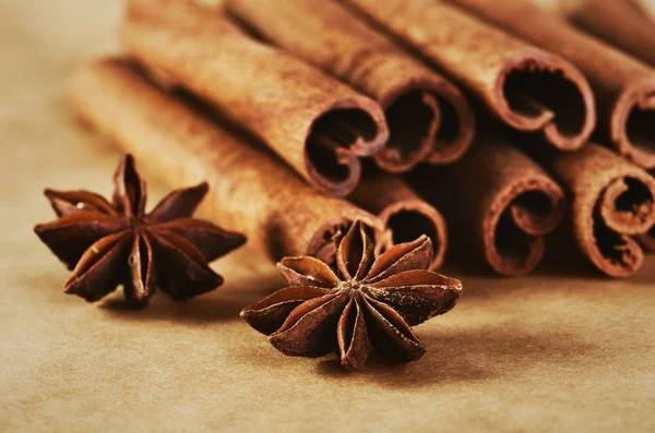 Cinnamon sticks and two stars anise on paper background close-up Royalty Free Stock Photos