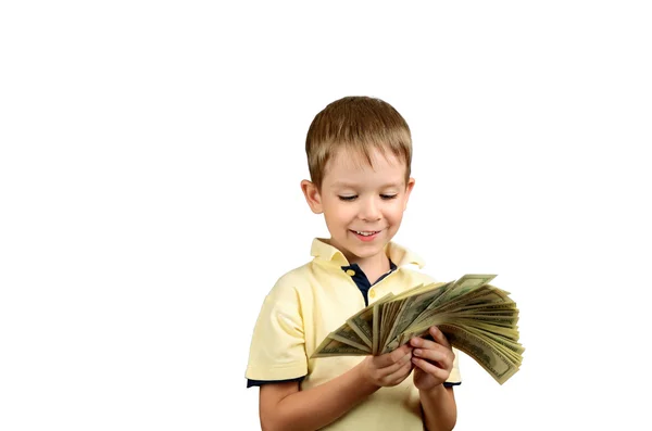 Menino sorrindo olhando para uma pilha de notas de 100 dólares americanos — Fotografia de Stock